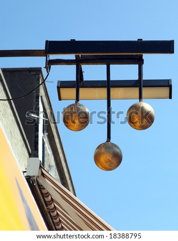 The famous three gold balls sign of a pawnbroker\'s shop, above a street in Great Yarmouth, Norfolk, eastern England.