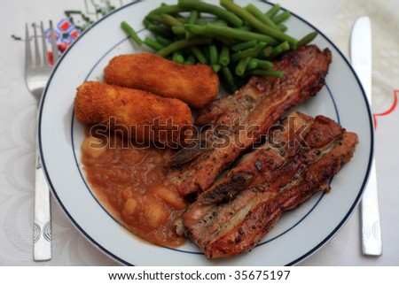 A meal of marinaded belly pork with potato croquettes, apple sauce and green beans