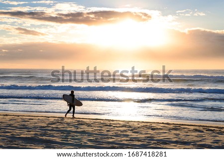 Similar – Image, Stock Photo Surfer at the beach carrying surfboard