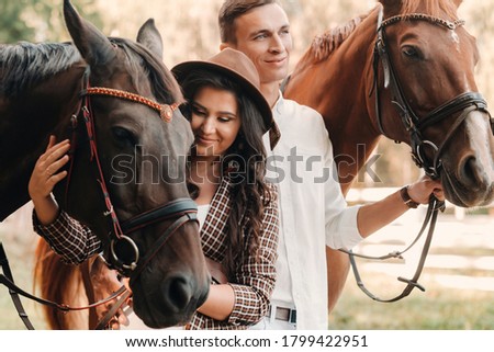 Similar – Image, Stock Photo A couple is horse riding on a meadow facing the distance. Romantic and active outdoor date. Autumn landscape, with young couple enjoying a horse riding. Overcast weather, beautiful horses.