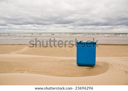 Trash box on the beach at the sea under cloudy sky