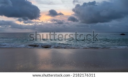 Tropical sunset. The sky between dark blue clouds is highlighted yellow, pink. Reflection on the surface of the ocean and the wet sand of the beach. Seychelles. Mahe. Beau Vallon Photo stock © 
