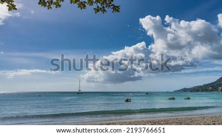 Serene seascape. Boats and yachts in the turquoise ocean. Green foliage against the sky and clouds. A wave rolls onto a sandy beach. Seychelles. Mahe. Beau Vallon Photo stock © 