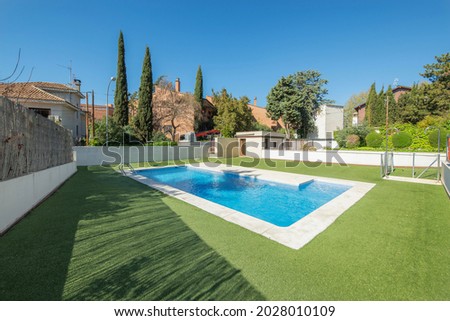 Summer pool surrounded by green grass with white marble go on a sunny day 商業照片 © 