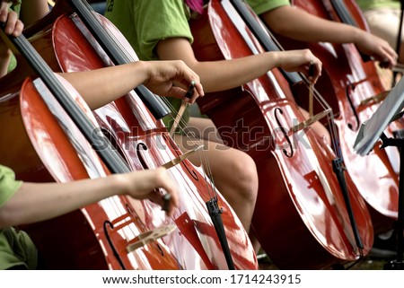 Children's hands bowing across cello fingerboards during an orchestral recital Stock foto © 