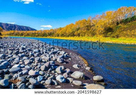 Rocky river bank in autumn time. River in autumn. Autumn river rocky beach. Autumn river landscape
