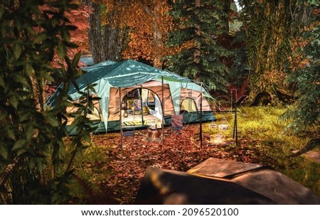 Tent in the autumn forest. Tent camp in autumn night forest. Night forest tent camp. Campfire in night forest tent camp