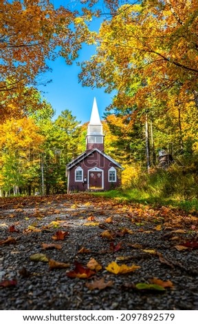 Village church in autumn colors. Church in autumn. Autumn road church. Village church in autumn scene