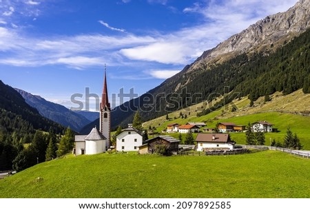 A village in the Alpine mountains. Mountain village landscape. Village in mountains. Alpine village in mountains