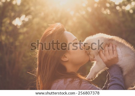 A women love puppy dog, kiss dog in nature