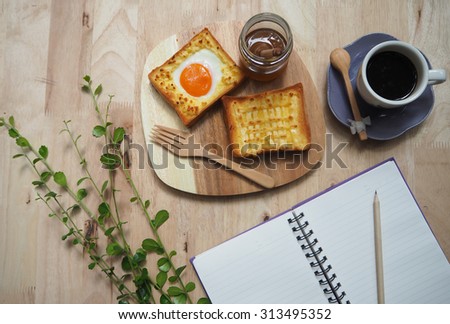 breakfast black coffee with toast and egg on wood table