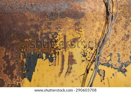 old rusty metal wire on a background of rusty metal surface painted with yellow paint, texture, background