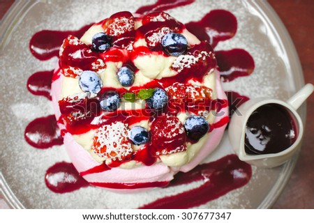 Merinque with fresh cream and homemade berry sauce serve with fresh berries, Top View