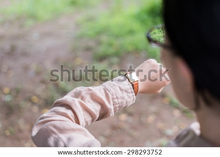 Asian woman looking at her watch