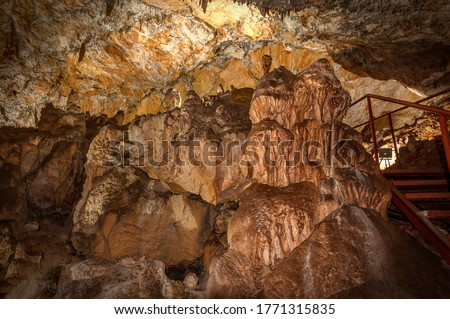 Little known cave Dobrostanski biser - Bulgaria. Large stalactite. Illuminated and ennobled cave in which are extremely rare cave pearls Imagine de stoc © 