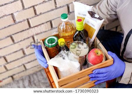 box with Food supplies crisis food stock for quarantine isolation period.Charity donations.Making Donations To Food Bank.A volunteer in rubber gloves.Delivery of products in isolation of coronavirus Foto d'archivio © 