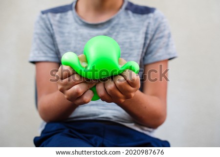 Teenage boy playing with anti stress sensory ball squeeze toy. Giant stress balls are soft to the touch and help reduce stress and anxiety as you pull, squish, smash, squash,  grip them in all kinds  Photo stock © 