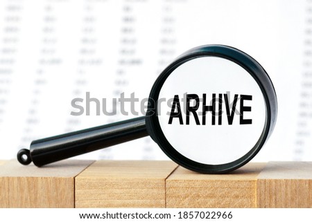 Look closely and arhive with a magnifying glass. Looking through a magnifier at the word arhive, a business concept. Magnifying glass on the background of columns of numbers. Imagine de stoc © 