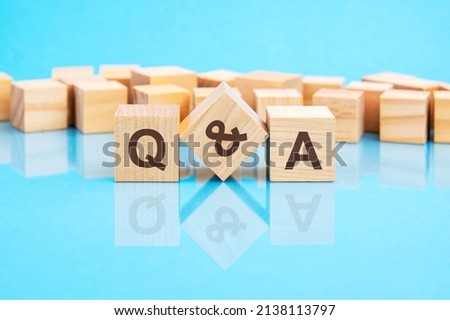 the text q and a written on the wooden cubes in black letters, the cubes are located on a bright blue glass surface. concept word forming with cubes on background - questions and answers. Stock foto © 