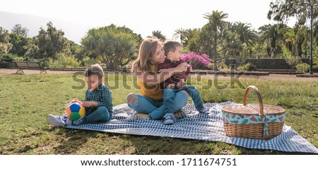 Young mother having fun with her two sons in a park - Love and family concept - Family having a pic nic - Focus on mother face Foto stock © 