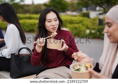 Image, Stock Photo Ethnic businesswoman eating sushi and working on laptop in cafe