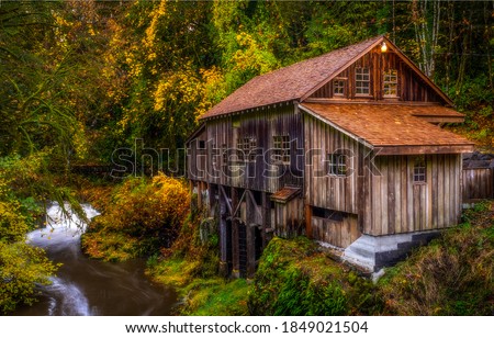 Forest hut in autumn woods. Hut at autumn forest creek. Forest hut autumn view. Autumn forest hut river