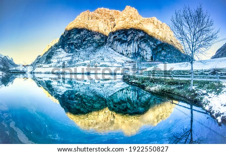 Winter mountain lake reflection view. Winter water reflection. Mountain winter snow reflectiob in water. Winter snow water reflection scene