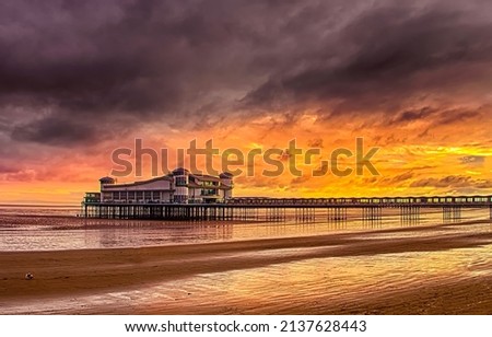 View from the beach to the pier at sunset. Sunset beach pier. Pier on sunset beach Foto d'archivio © 