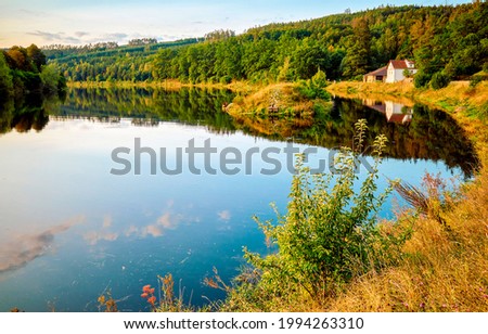Lake house on the shore of the autumn forest. Autumn lake in forest. Lake house in autumn scene