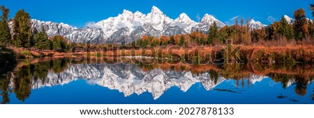 Snow peaks are reflected in the lake. Mountain lake panorama. Mountain lake panoramic landscape. Lake in mountains
