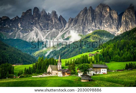 A small church in a mountain village. Village in mountain green valley. Mountain green valley village scene. Village in mountains