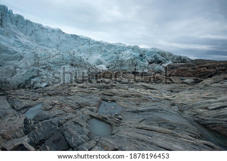 melting glaciers in Greenland. Summer time in Greenland. Warming climate. Travel to Kangerlussuaq Greenland. Glacier moving over the stones. streams of water rush through the tundra to the ocean. 