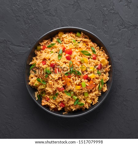 Veg Schezwan Fried Rice in black bowl at dark slate background. Vegetarian Szechuan Rice is indo-chinese cuisine dish with bell peppers, green beans, carrot. Top view Сток-фото © 