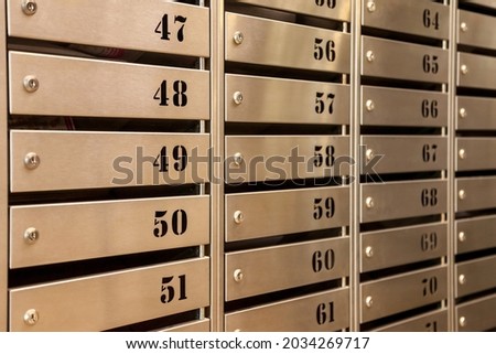 Steel Mailboxes in an apartment residential building. Even rows of numbered mailbox. Correspondence concept in city. You can use it as background for your creative. Copy space
