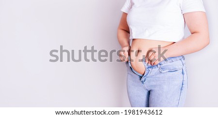 a woman dresses in jeans after giving birth. The concept of the diet-close-up of women's hands can not button their pants because of the increase in fat on the thighs after childbirth. Сток-фото © 