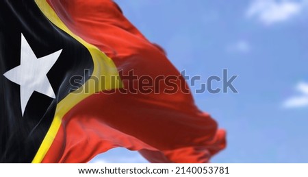 Detail of the national flag of East Timor waving in the wind on a clear day. East Timor is an island country in Southeast Asia. Selective focus. 商業照片 © 