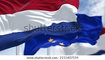 Detail of the national flag of the Netherlands waving in the wind with blurred european union flag in the background on a clear day. Democracy and politics. European country. Selective focus. 商業照片 © 