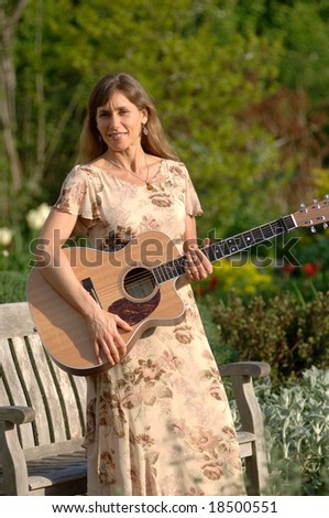 Woman with guitar in garden