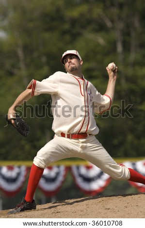 Baseball pitcher on mound about to pitch a baseball. Vertically framed shot.