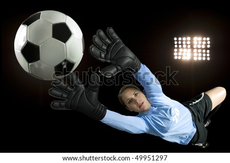 soccer goalie blocks ball in stadium