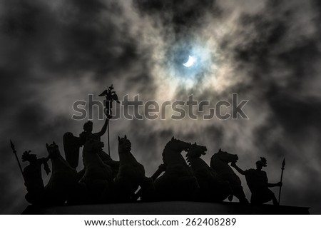 Total Solar Eclipse of March 20th, 2015 (partial phase) photographed behind a dramatic cloudy sky and a triumphal car on top of General Staff Building at Palace Square in Saint-Petersburg, Russia