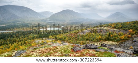Wide panoramic view of Kunijok valley with mounts and Kukisvumchorr plateau with taiga forest, lakes and tundra in foreground, shot from slope, Hibiny mountains above the Arctic Circle, Russia