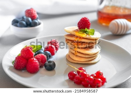 Similar – Image, Stock Photo Mini pancakes with butter and blueberries lie in a plate on a wooden table. Brunch, dessert for children, trending food. Space for text