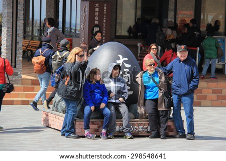 Hakone, Japan - April 9, 2015: Tourists are taking photos with Black Egg sculpture at Owakudani, well known for black eggs or eggs hard-boiled in hot springs.
