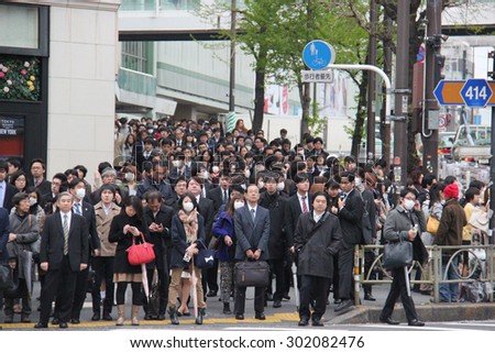Tokyo, Japan - April 12, 2015: Hundreds of People are waiting for crossing the street at Shinjuku, a major commercial and administrative center, housing the busiest railway station in the world.