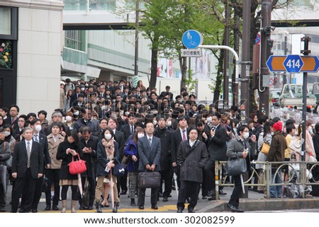 Tokyo, Japan - April 12, 2015: Hundreds of People are waiting for crossing the street at Shinjuku, a major commercial and administrative center, housing the busiest railway station in the world.
