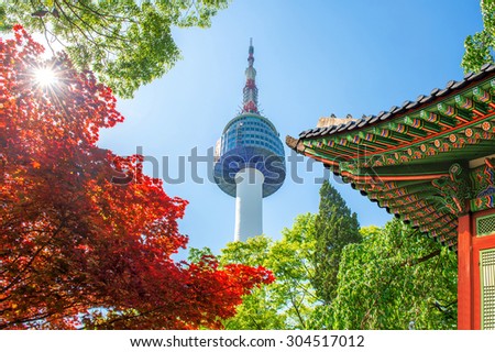 Seoul Tower with gyeongbokgung roof and red autumn maple leaves at Namsan mountain in South Korea.