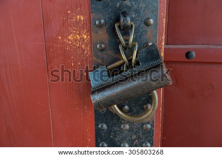 Old rusty lock on the wooden gate.