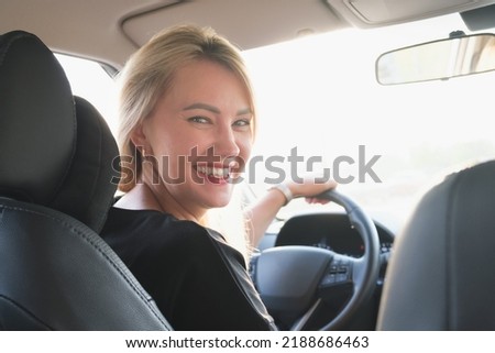 Similar – Image, Stock Photo Woman sitting on driver seat and putting on gloves