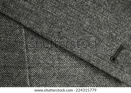 Detail of lapel and front pocket of a classic gray woolen tweed coat